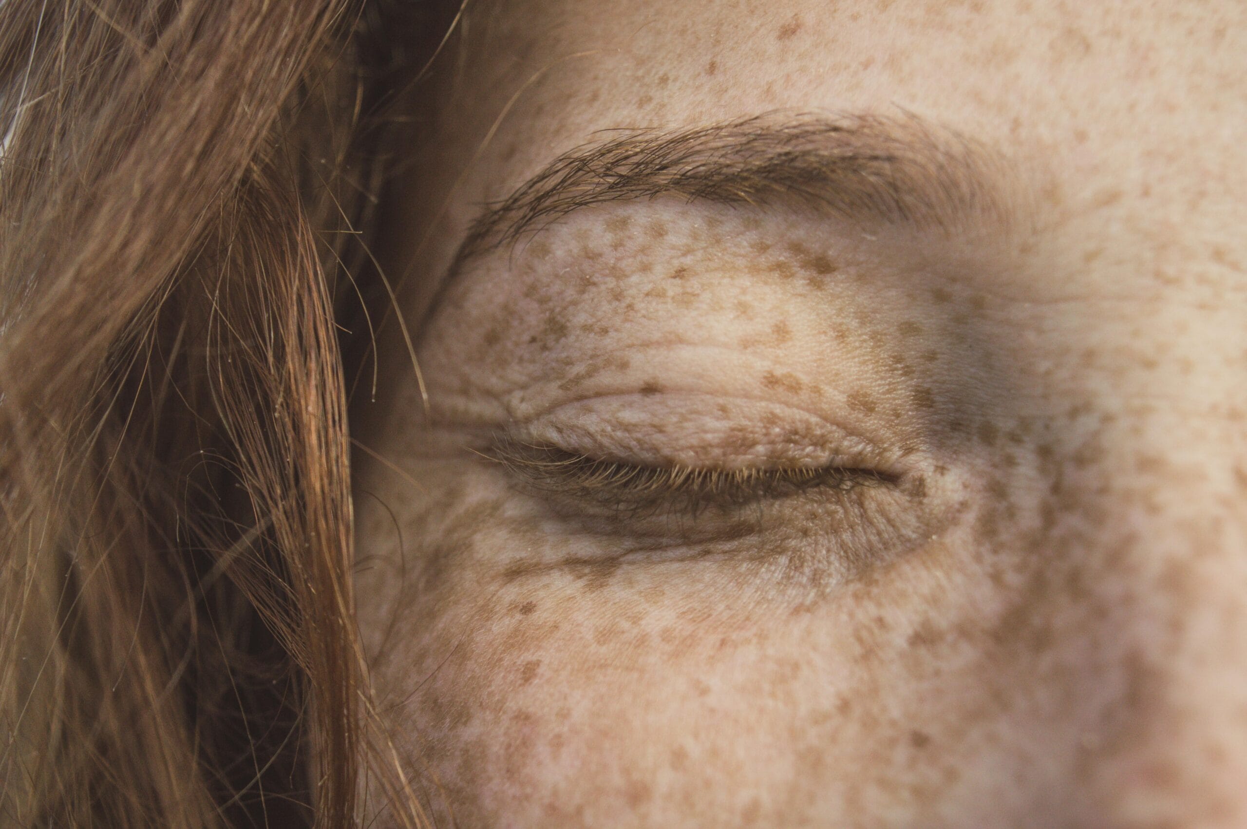 A red-haired woman's closed eye.